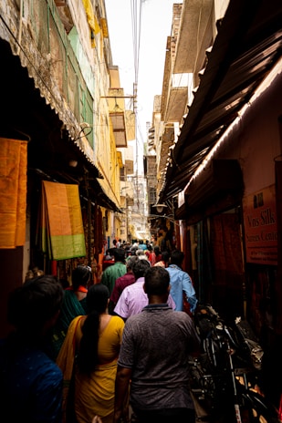 a crowd of people walking through a narrow alley