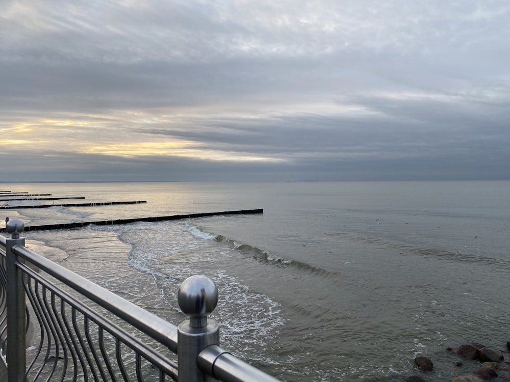 a body of water with a dock and a railing