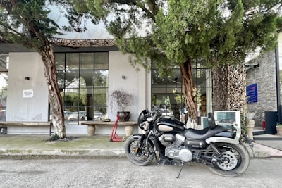 A stylish motorcycle parked in front of a modern urban building with reflective glass.