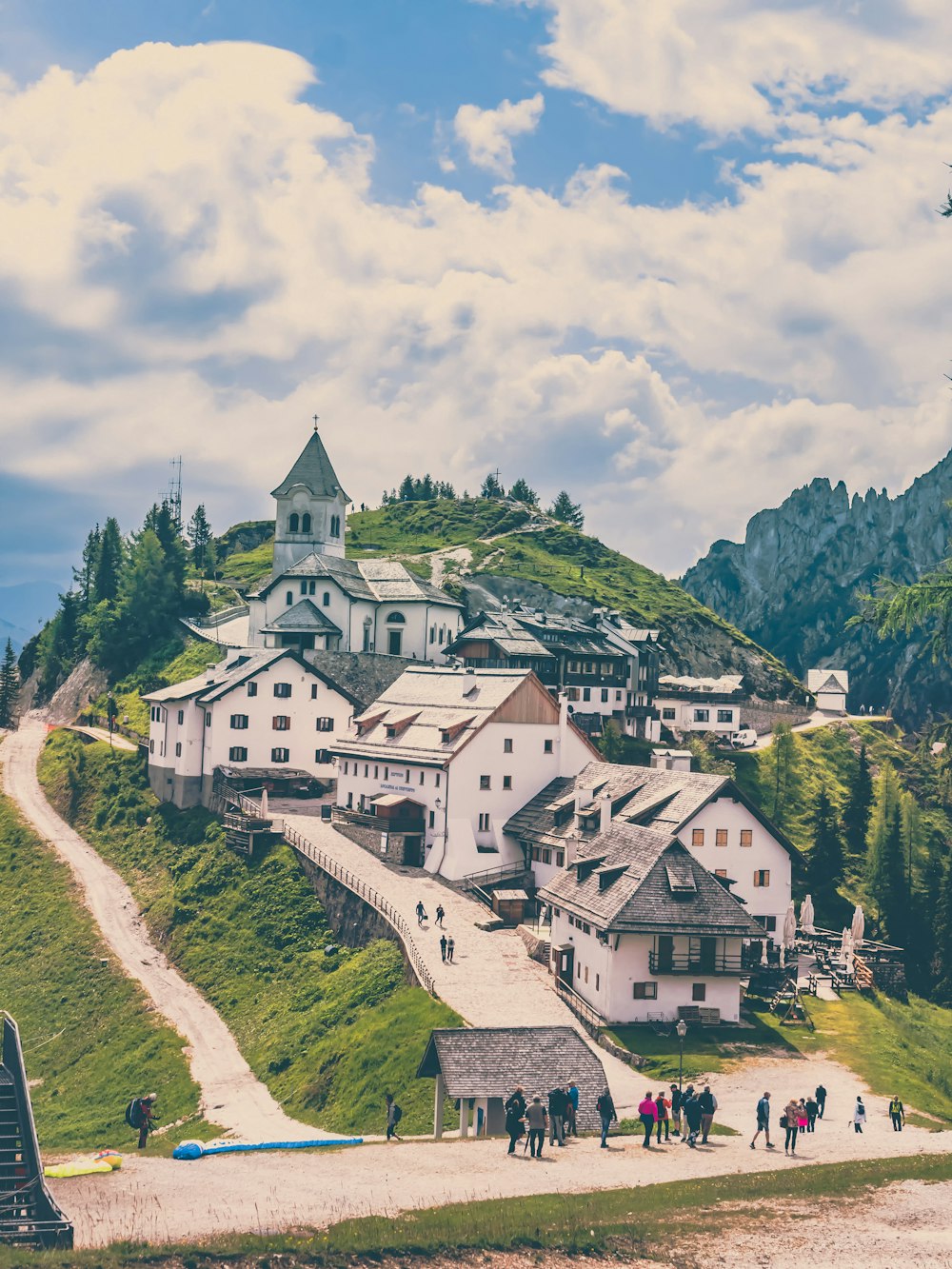 a group of people walking around a building on a hill