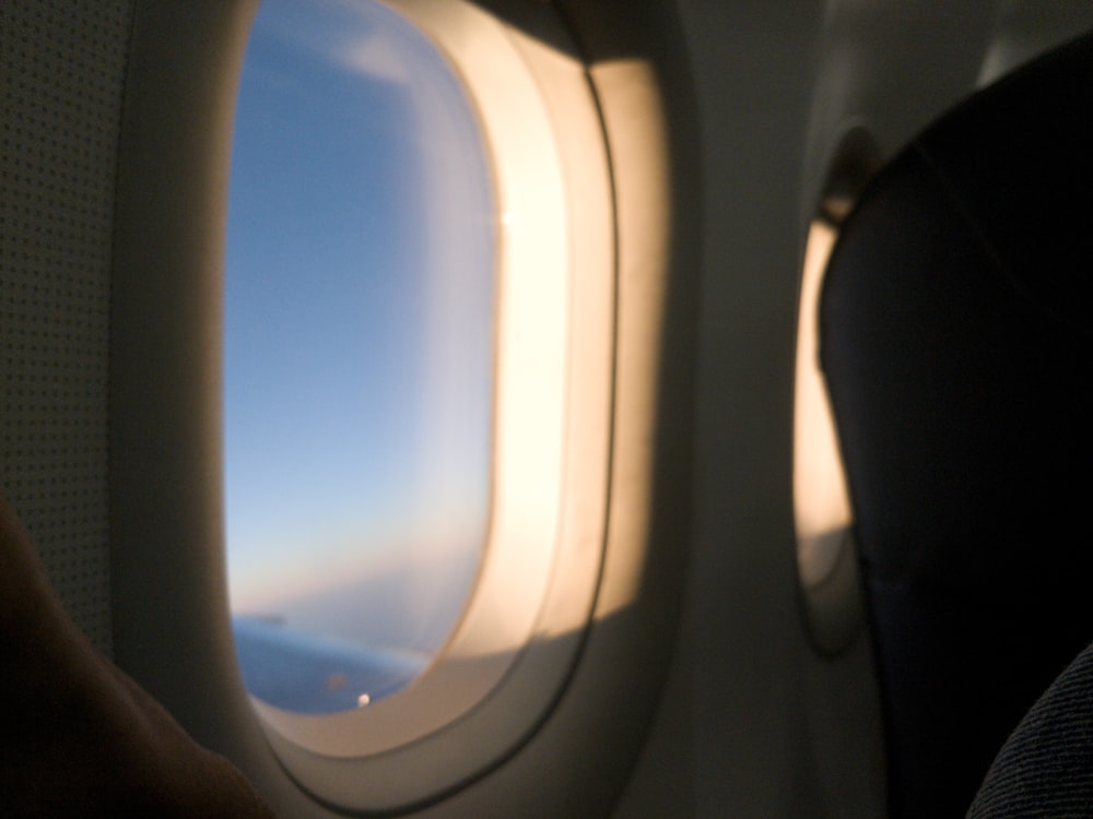 an airplane wing with the sun shining through the window