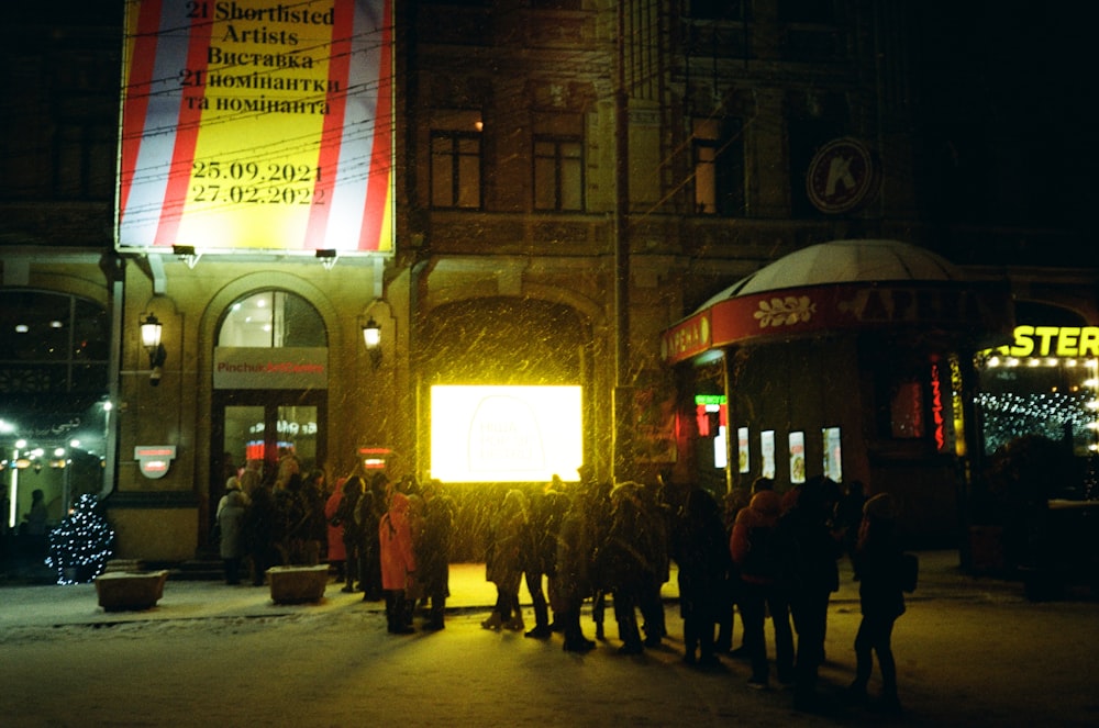 a group of people walking in a street at night