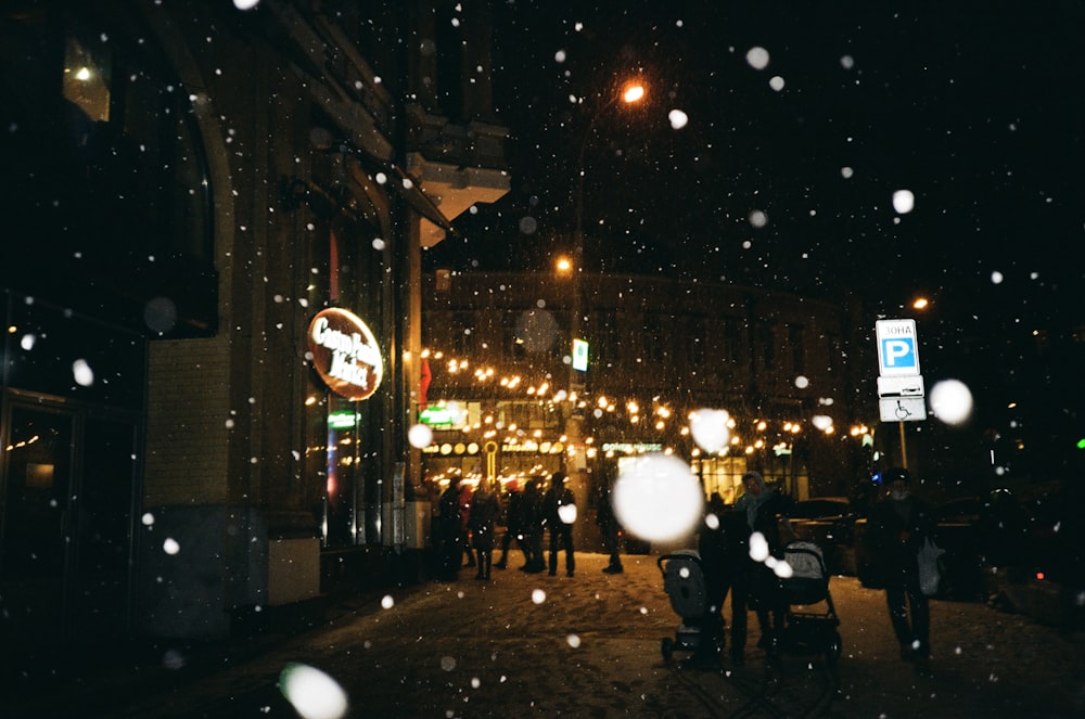 a group of people standing on a street at night