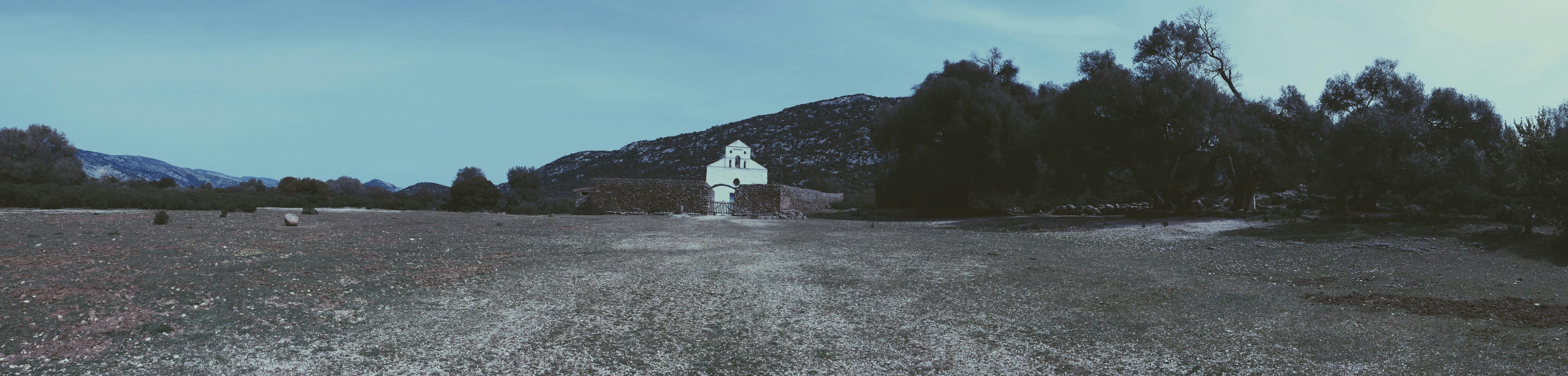 A landscape with trees and a building in the distance photo – Free ...