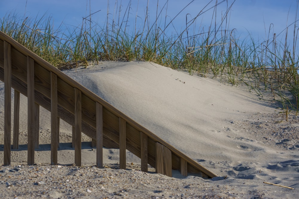 a wooden bridge over a sandy area