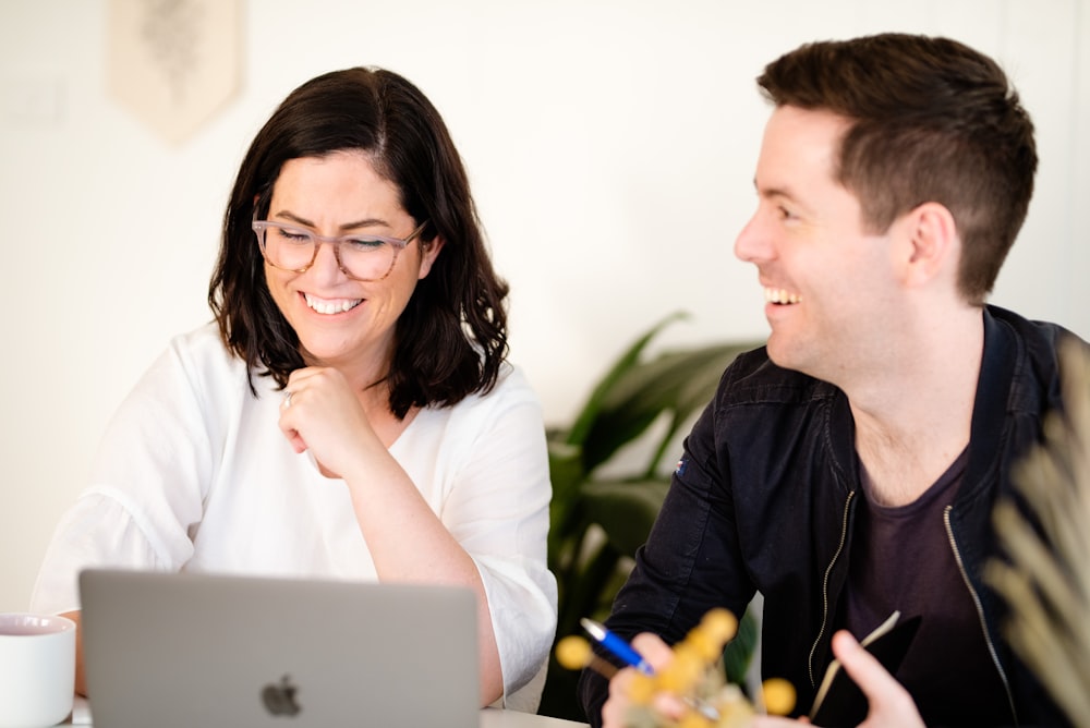 a man and a woman looking at a laptop