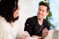 A friendly support agent answering a client's questions through live chat.