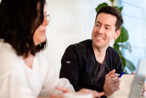 A friendly person interacting with a digital AI assistant on a laptop.