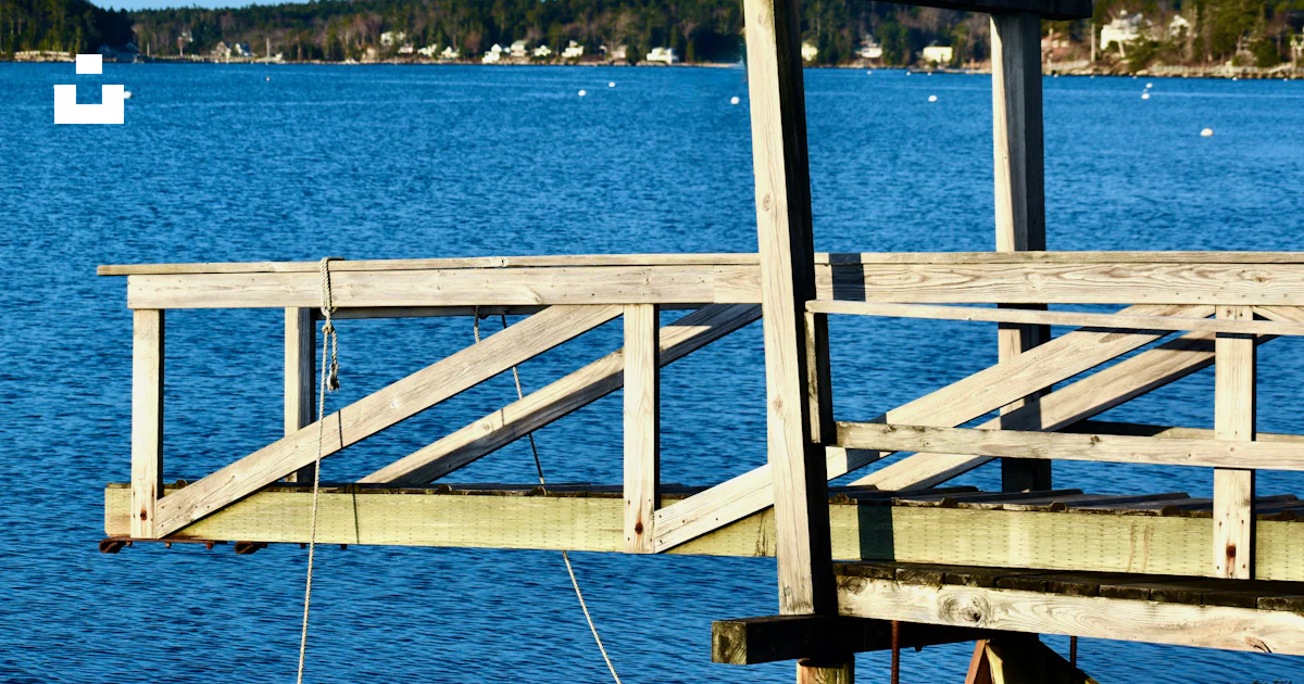 A wooden railing on a dock over water photo – Free Usa Image on Unsplash