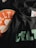A close-up of black fabric featuring printed designs, including the text 'Celtics' and an NBA logo, as well as elements resembling a basketball texture in orange and white.