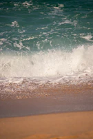 White sandy beach with turquoise waves gently reaching the shore.