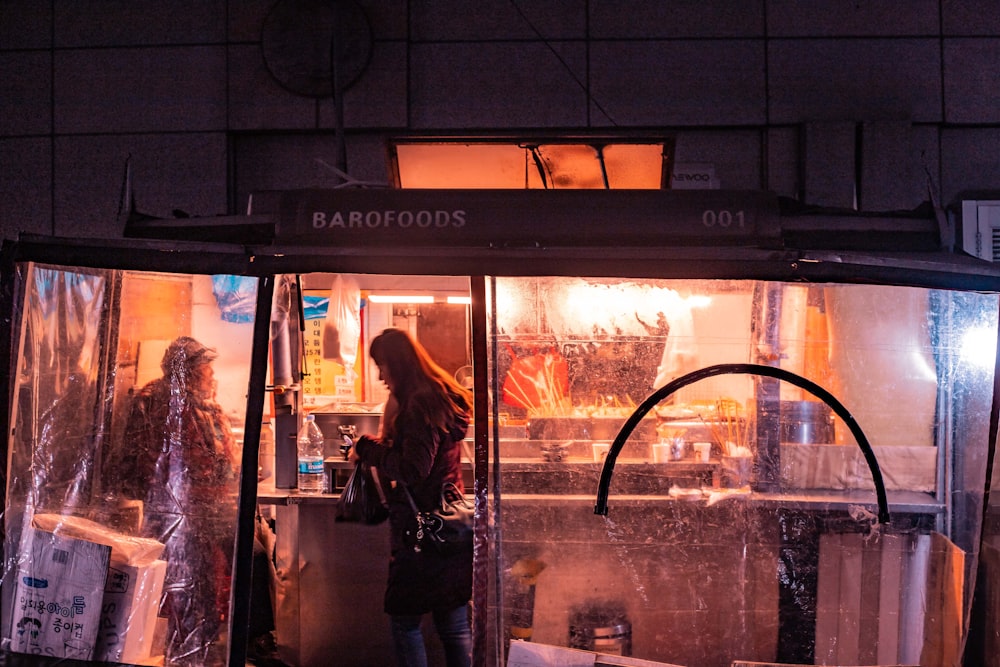 a person standing in front of a window with a reflection of a person in it