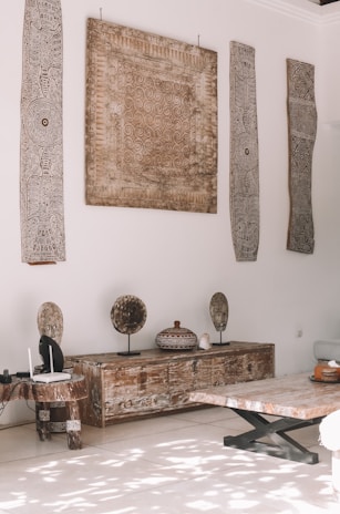 a room with a table and a bench with a painting on the wall