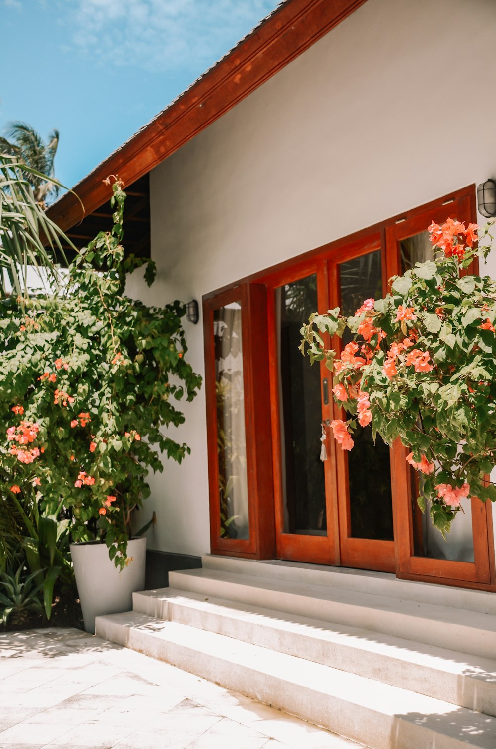 ein Haus mit einem großen Fenster und Blumen an der Seite