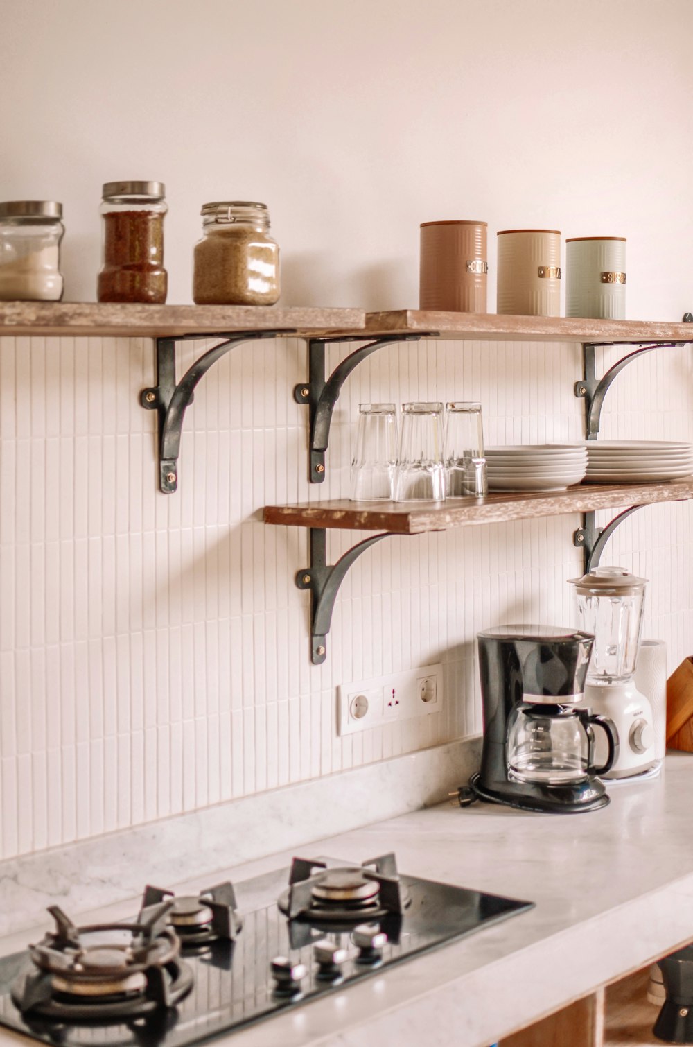 a kitchen with a shelf full of jars and a coffee maker