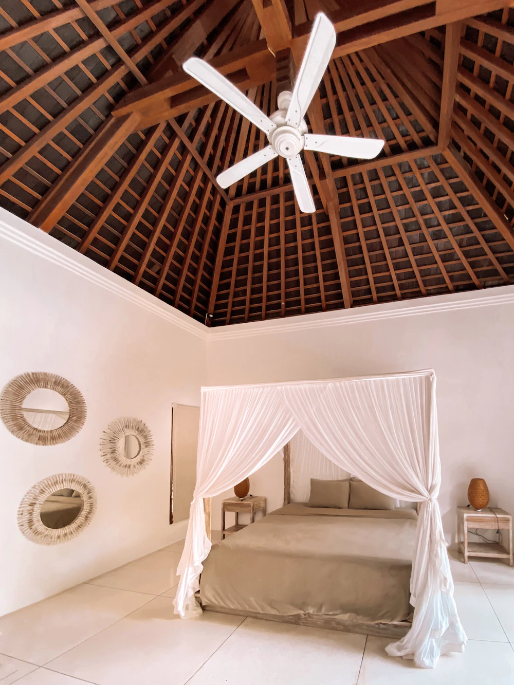 Kamar dengan ranjang kelambu di bawah atap kayu