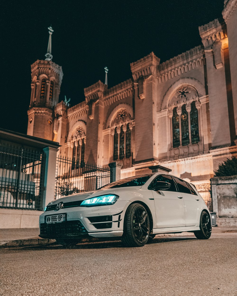 a white car parked in front of a building