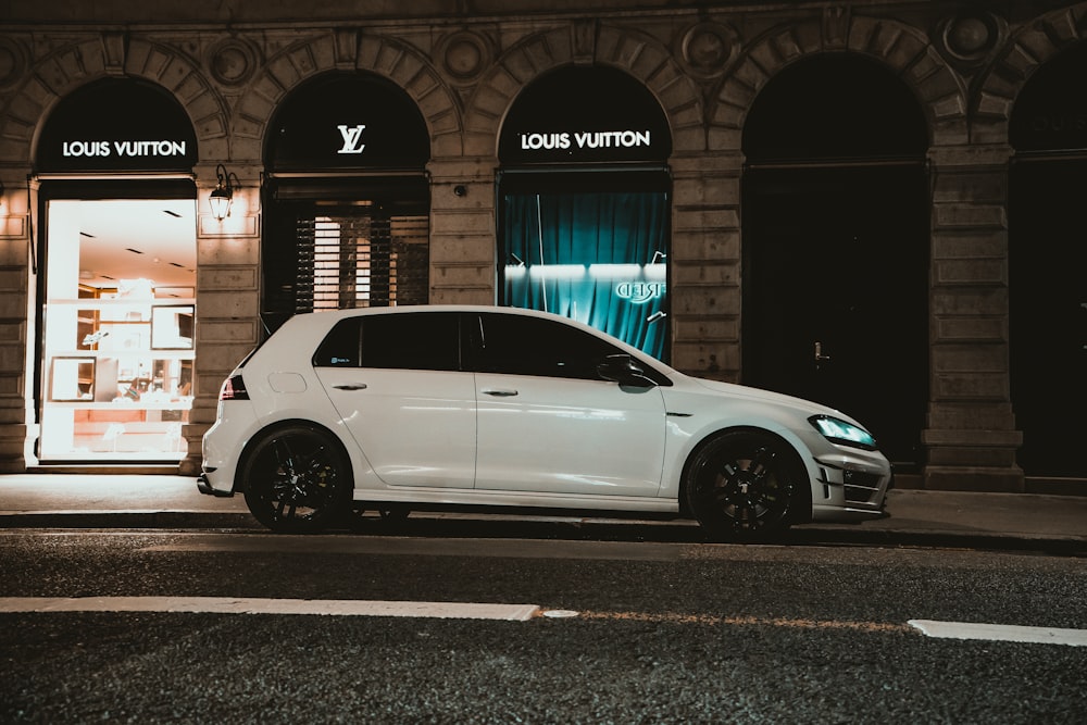 a white car parked in front of a building