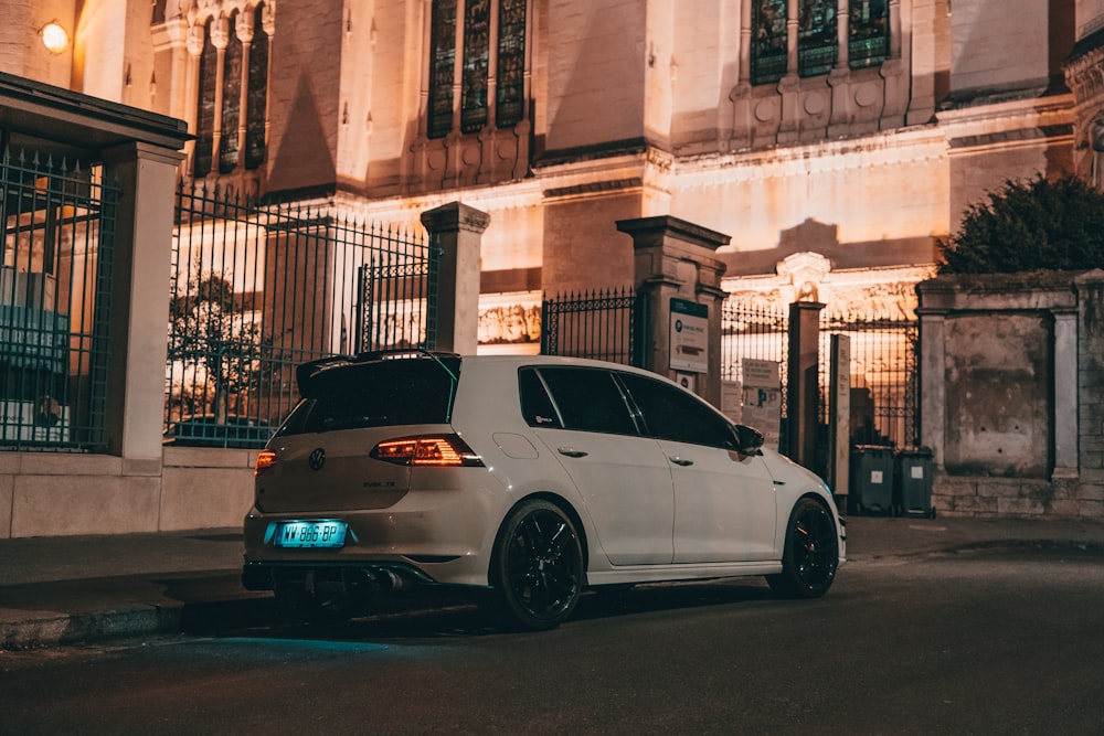 a white car parked on the side of a street