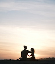 Couple enjoying a sunset on a tropical beach during their honeymoon.
