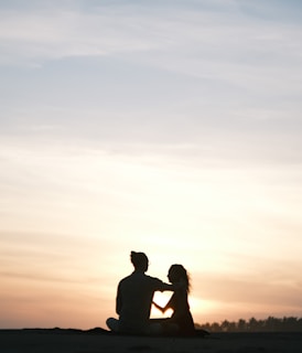 Couple enjoying a sunset on a tropical beach with palm trees.