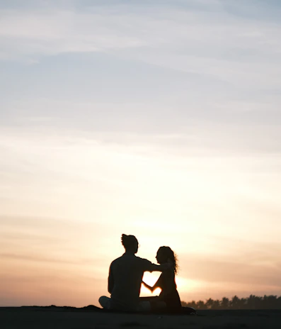 Couples enjoying a peaceful sunset on the soft sands, framed by swaying palm trees.