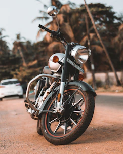 A classic cruiser motorcycle parked near a beach during sunset.