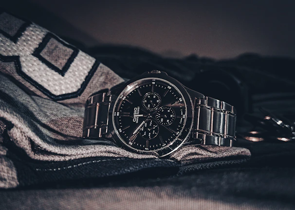 A stylish gold-tone mechanical watch laid on textured dark fabric highlighting its finely crafted details.