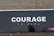 Close-up of a sturdy cdhmr board with a smooth finish, branded courage®️, set against a construction site backdrop.