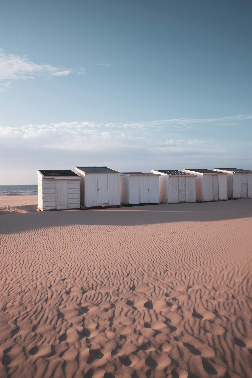 Un gruppo di contenitori bianchi su una spiaggia sabbiosa