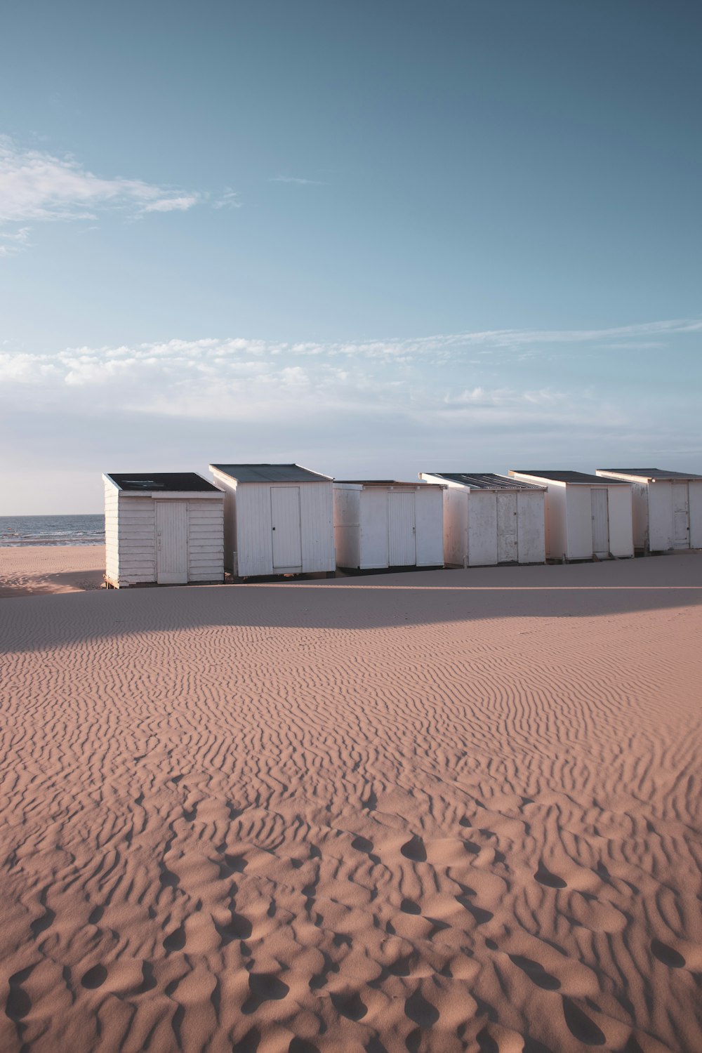 um grupo de recipientes brancos em uma praia de areia