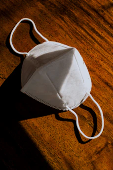 Fresh sheet mask laid out on a wooden surface with green leaves