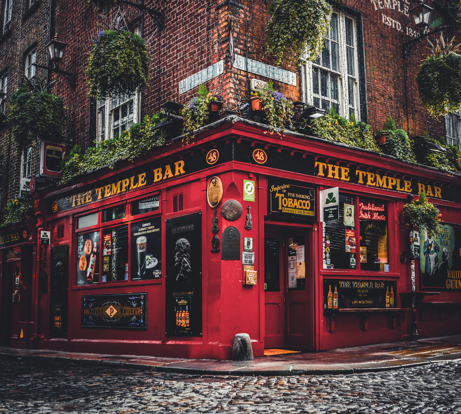 The red frontage of the Temple Bar pub in Dublin, hung with flowers
