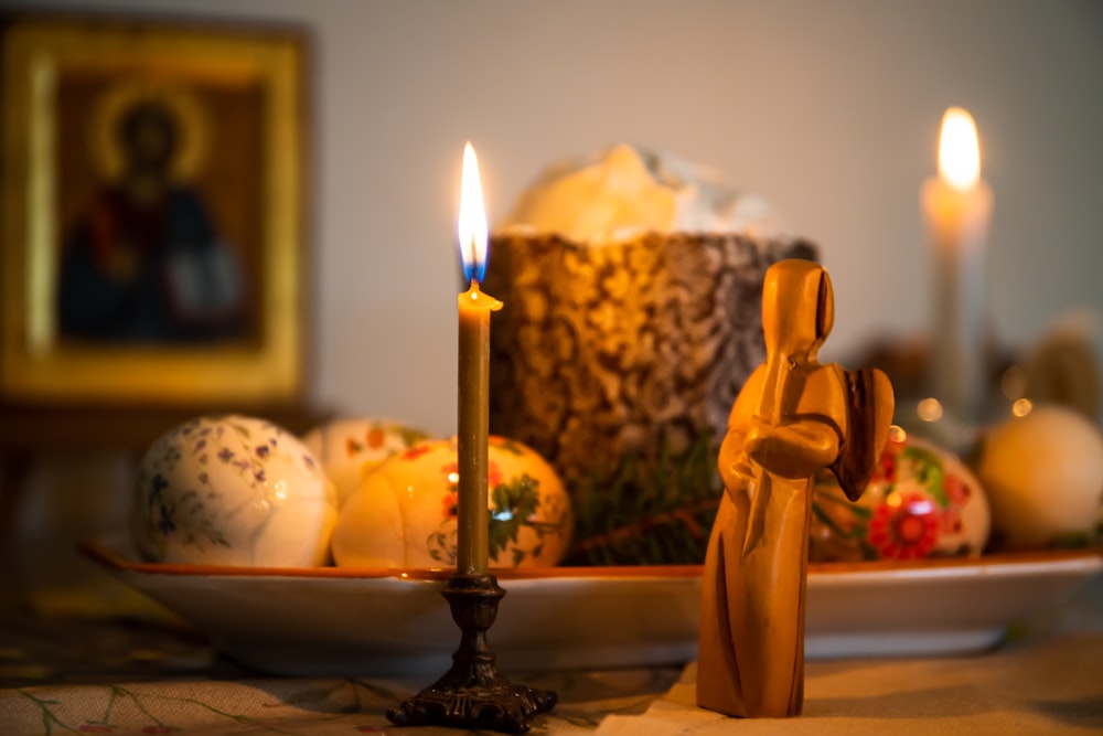 a candle in a bowl of fruit