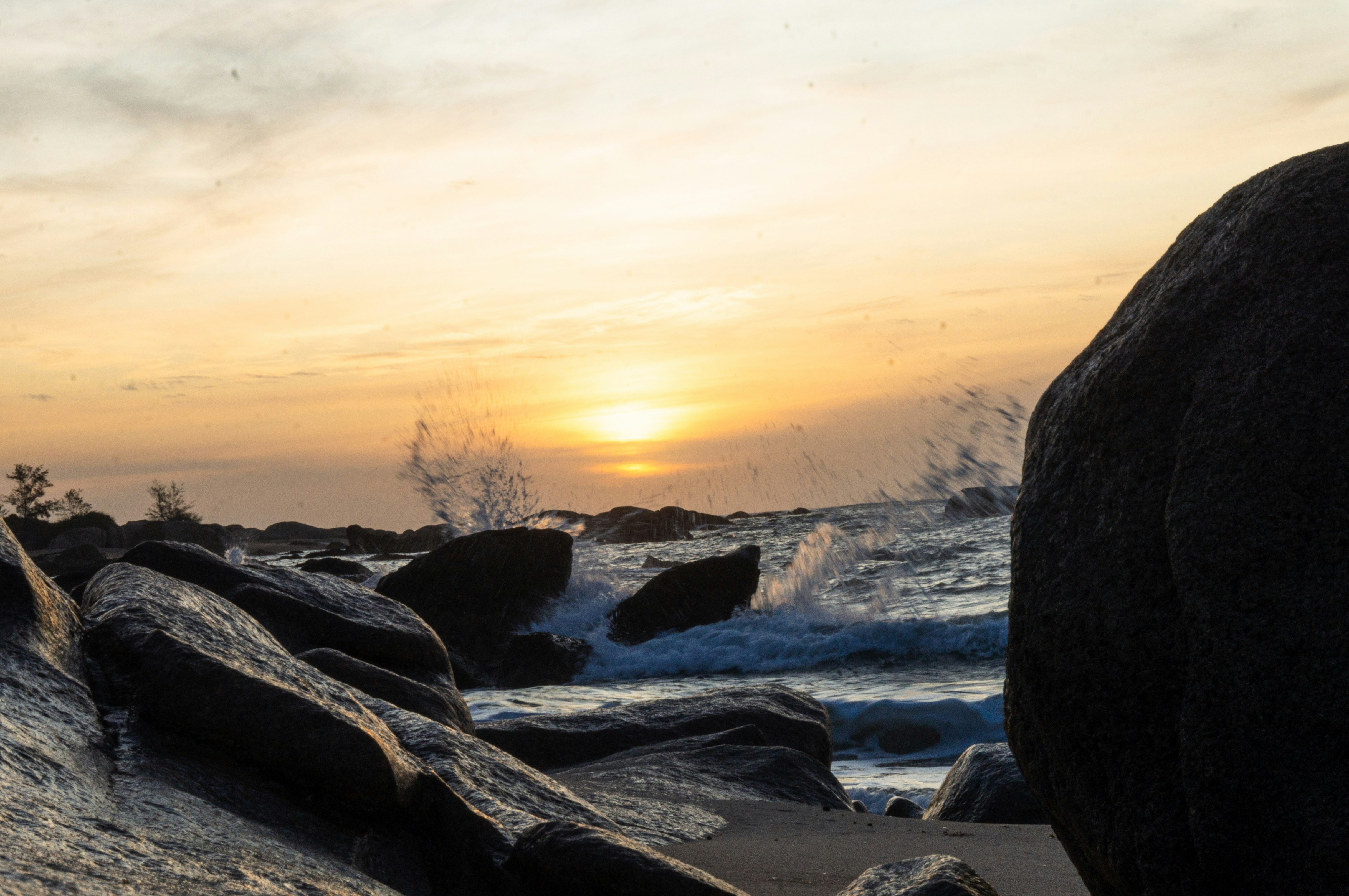 a rocky beach with a sunset, 