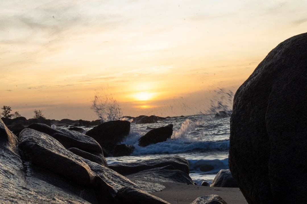 a rocky beach with a sunset,