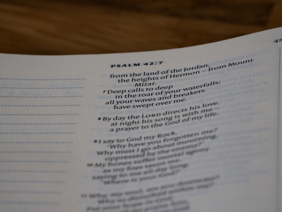 A close-up view of a page from a Bible open to Psalm 42:7. The text is focused on verses discussing spiritual themes, with some text in bold for emphasis. The page has a clean, white background with neatly printed black text.