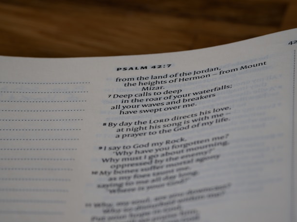 A close-up view of a page from a Bible open to Psalm 42:7. The text is focused on verses discussing spiritual themes, with some text in bold for emphasis. The page has a clean, white background with neatly printed black text.