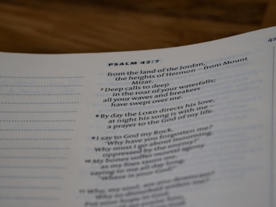 A close-up view of a page from a Bible open to Psalm 42:7. The text is focused on verses discussing spiritual themes, with some text in bold for emphasis. The page has a clean, white background with neatly printed black text.