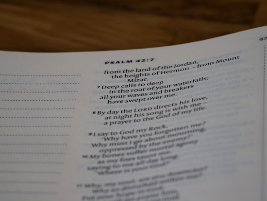 A close-up view of a page from a Bible open to Psalm 42:7. The text is focused on verses discussing spiritual themes, with some text in bold for emphasis. The page has a clean, white background with neatly printed black text.