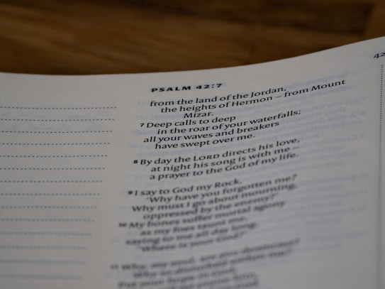 A close-up view of a page from a Bible open to Psalm 42:7. The text is focused on verses discussing spiritual themes, with some text in bold for emphasis. The page has a clean, white background with neatly printed black text.