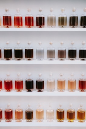 A neatly arranged laboratory shelf filled with colorful chemical bottles and glassware.
