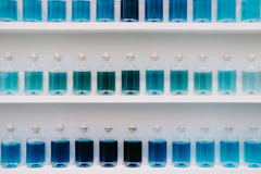 a group of blue bottles on a white shelf