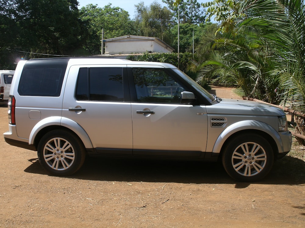 a white suv parked on a dirt road