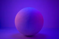 A smooth rose quartz sphere illuminated by a subtle cosmic glow against a deep purple backdrop.