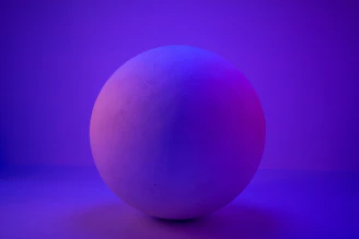 A neon-lit 3D sphere glowing softly against a deep violet-to-black gradient background.