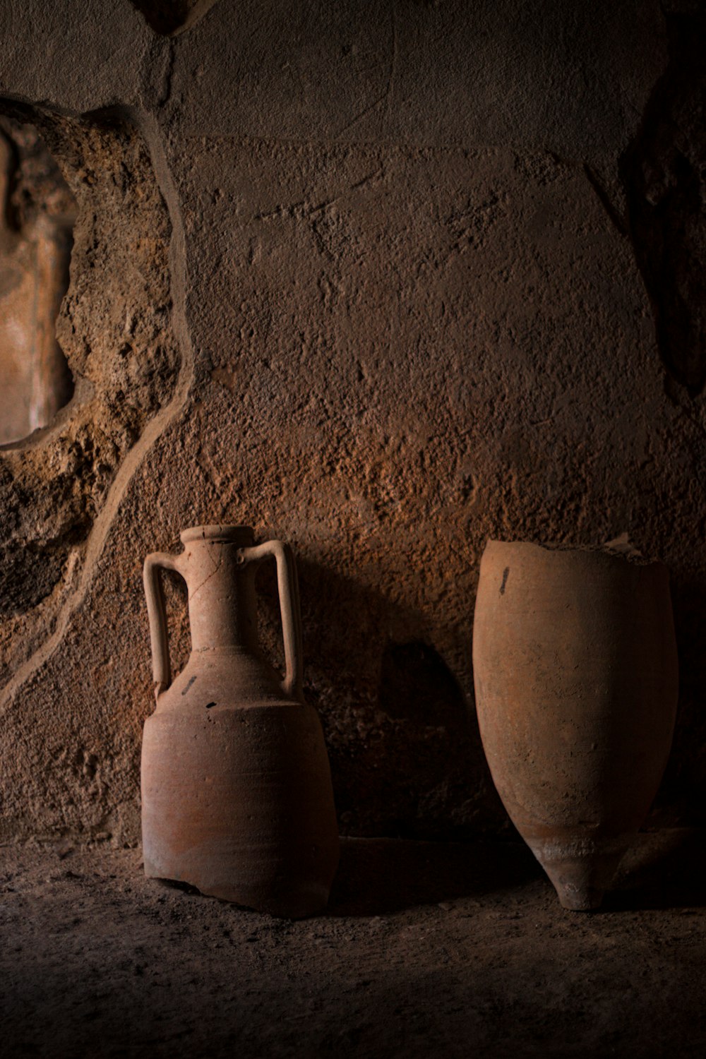 a couple of vases sit in a corner of a room