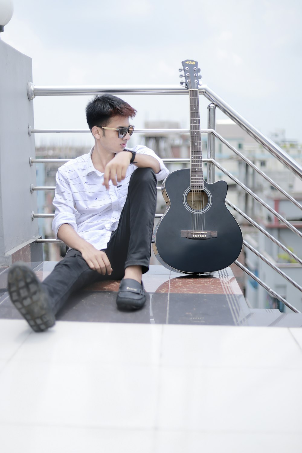 a person sitting on a staircase with a guitar