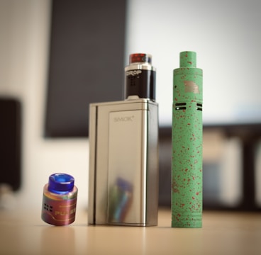 a green and white tube next to a white and black tube with a green tube and a blue