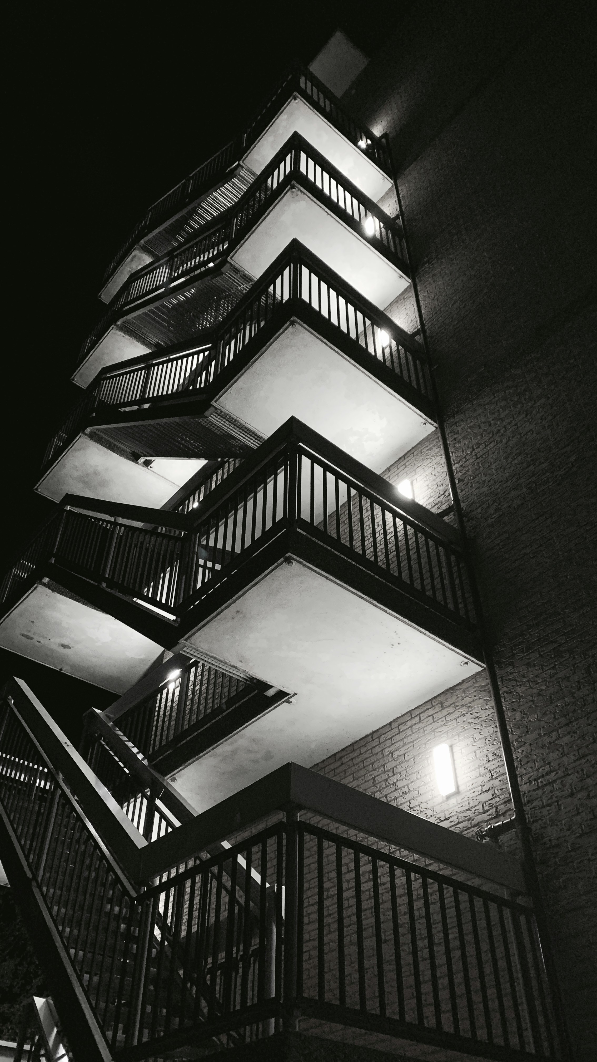 Dark luxury building exterior at night, city lights, deep shadows, atmospheric urban scene